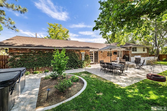 back of property featuring a lawn and a patio area