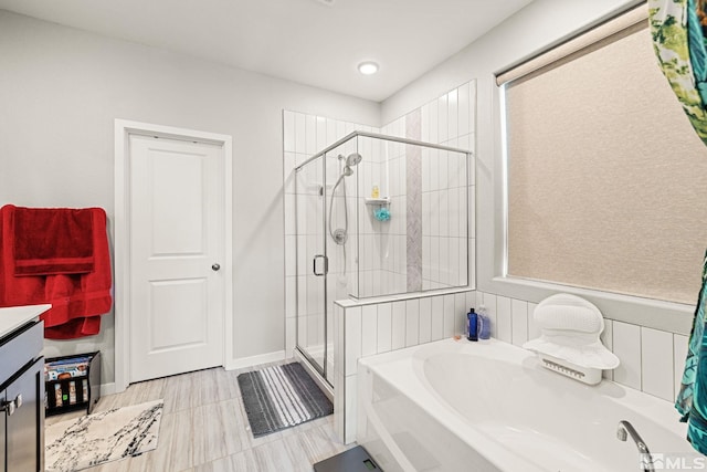 bathroom with vanity and shower with separate bathtub