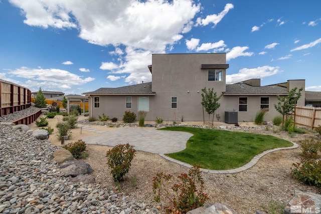 rear view of house with central AC and a patio area