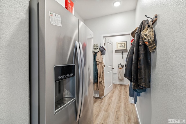 interior space featuring light wood-type flooring and stainless steel fridge