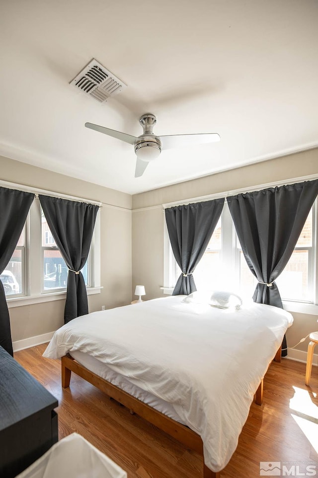 bedroom with hardwood / wood-style floors and ceiling fan