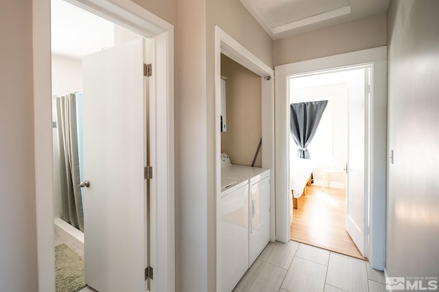 laundry area with washer and clothes dryer and light tile floors