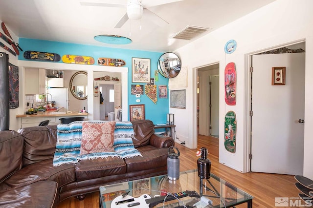 living room featuring ceiling fan and light hardwood / wood-style flooring