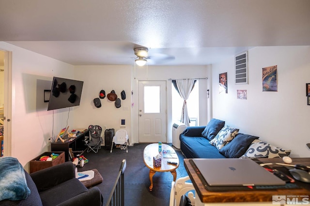 carpeted living area featuring a ceiling fan and a textured ceiling