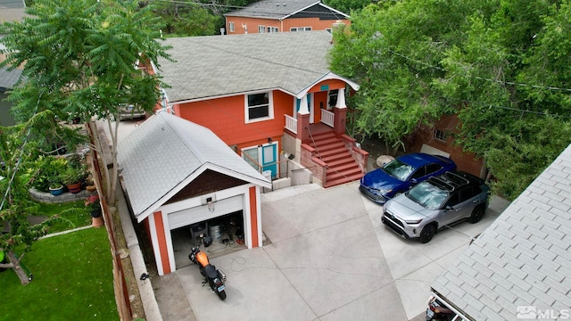 view of front of property with a garage, a shingled roof, and stairway