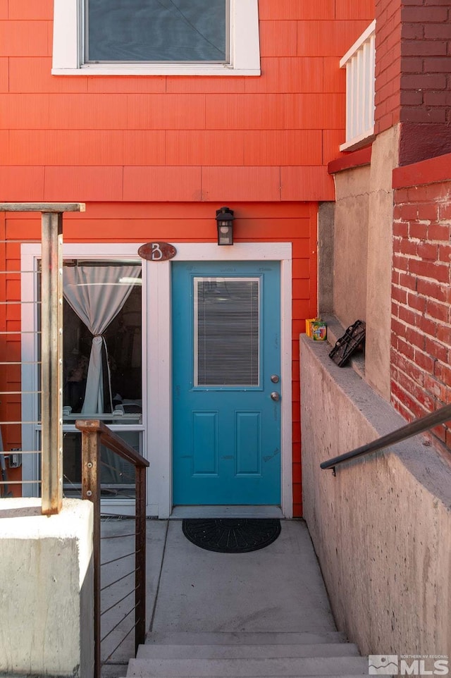 entrance to property featuring brick siding