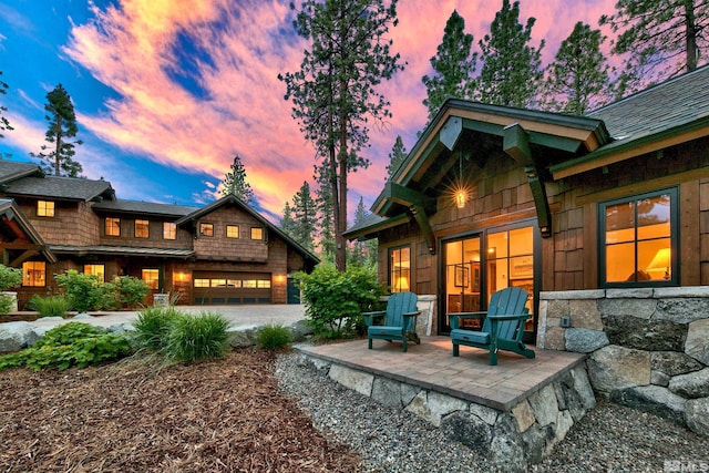 back house at dusk with a patio area