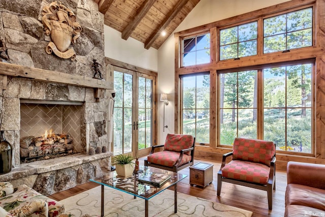 living room featuring french doors, beamed ceiling, high vaulted ceiling, a fireplace, and wood ceiling