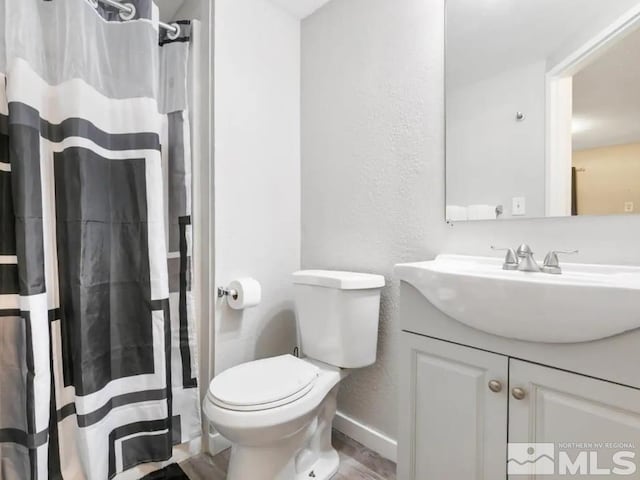 bathroom with a shower with shower curtain, vanity, and toilet