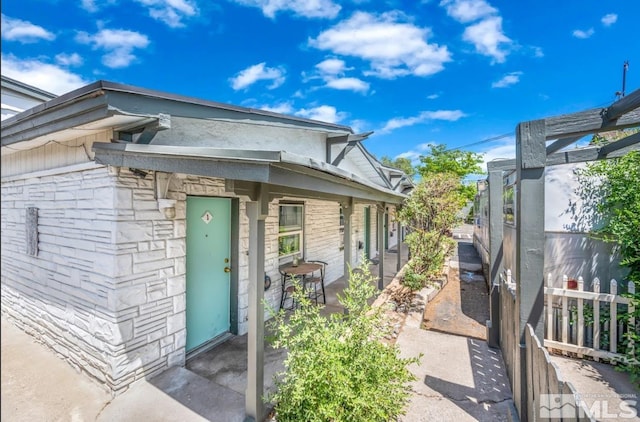 view of exterior entry with a patio area