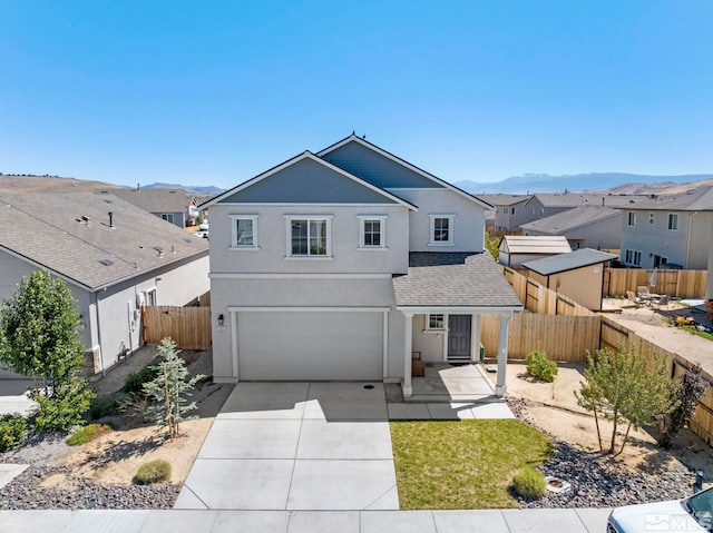 front of property with a garage and a mountain view