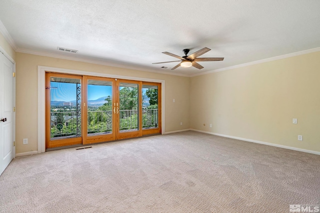 carpeted spare room featuring crown molding, french doors, ceiling fan, and a textured ceiling