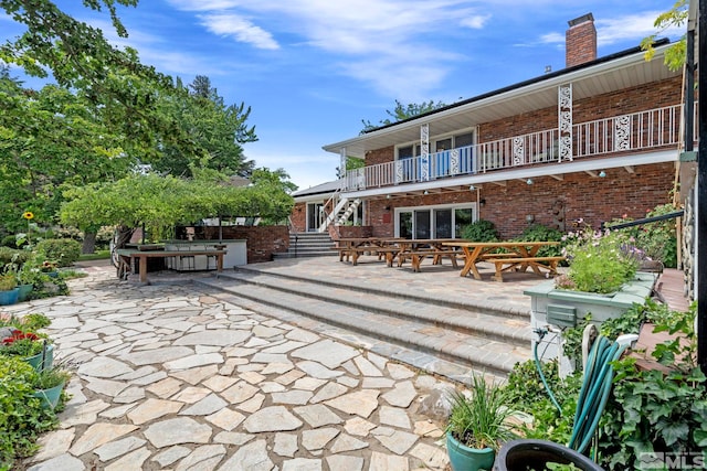 rear view of property with a patio and a balcony