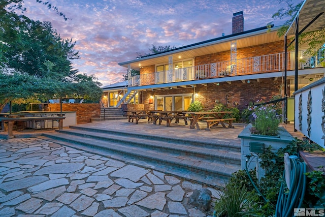 pool at dusk featuring a patio area