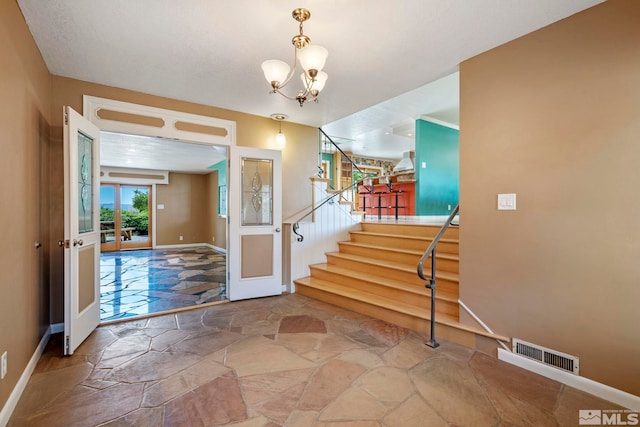 foyer featuring a notable chandelier and french doors