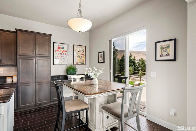 dining area featuring baseboards, a mountain view, and wood tiled floor