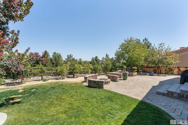 view of yard featuring a patio area, fence, and a fire pit