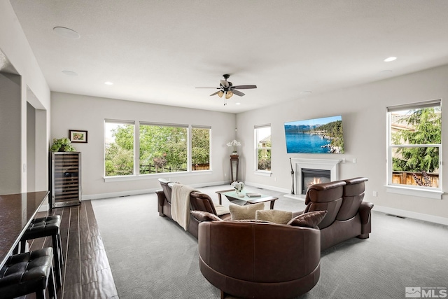 living room featuring carpet, ceiling fan, and plenty of natural light