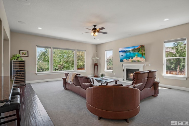 carpeted living room featuring wine cooler, recessed lighting, a glass covered fireplace, and baseboards