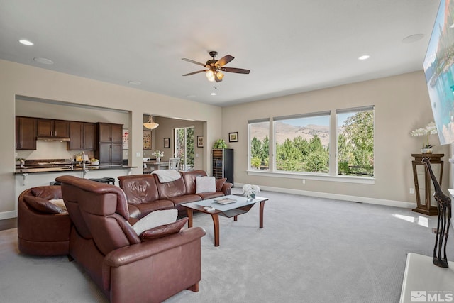 living room featuring light carpet, recessed lighting, and baseboards