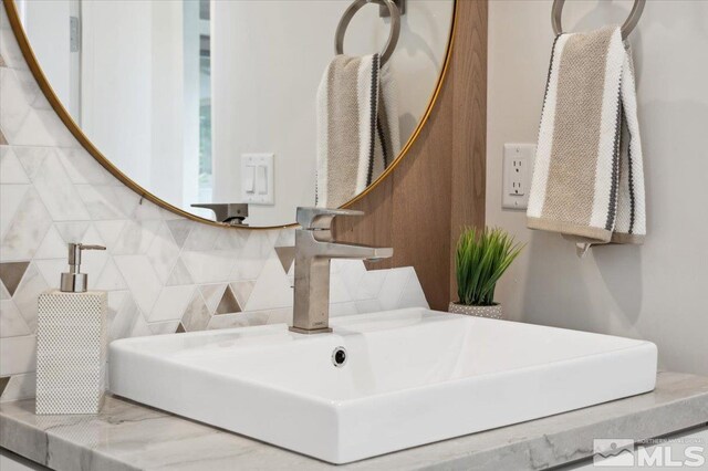 bathroom with tasteful backsplash and sink