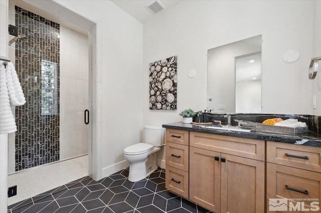 bathroom with tile patterned floors, vanity, toilet, and an enclosed shower