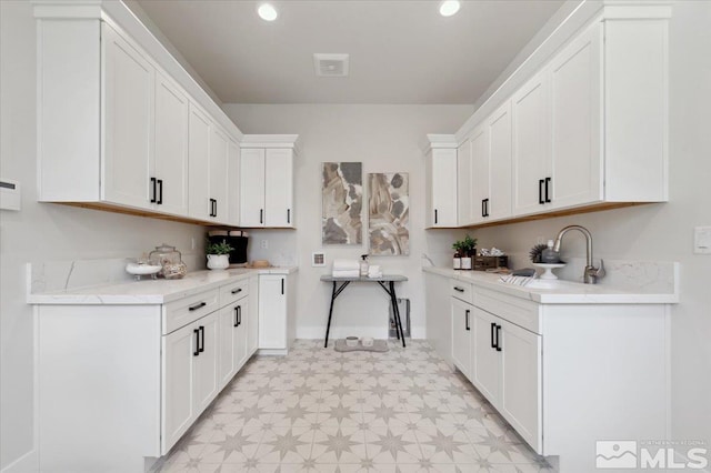 kitchen with white cabinetry and sink