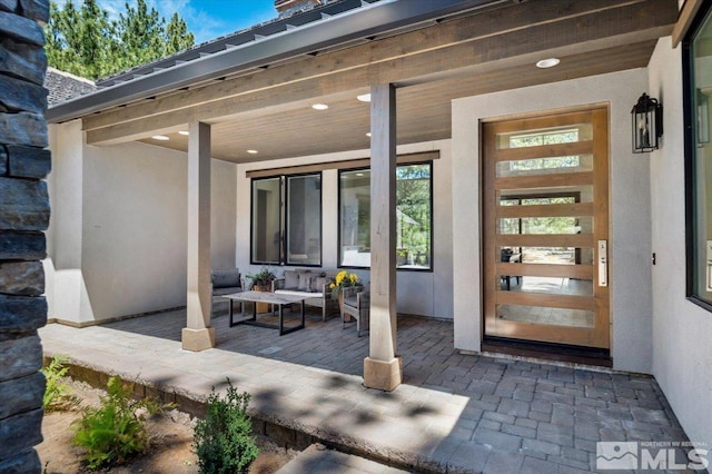 doorway to property with outdoor lounge area and a patio area