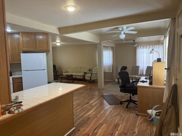 office featuring ceiling fan, dark wood-type flooring, and a textured ceiling