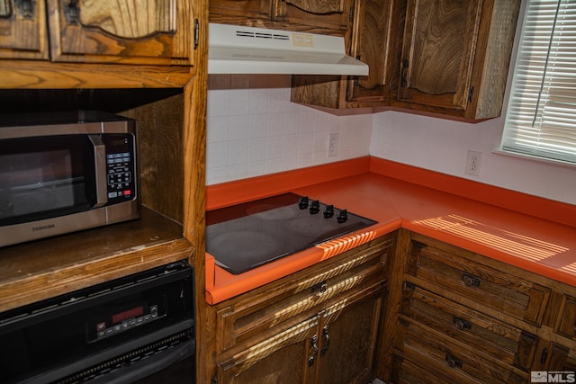 kitchen featuring wall oven and black electric cooktop