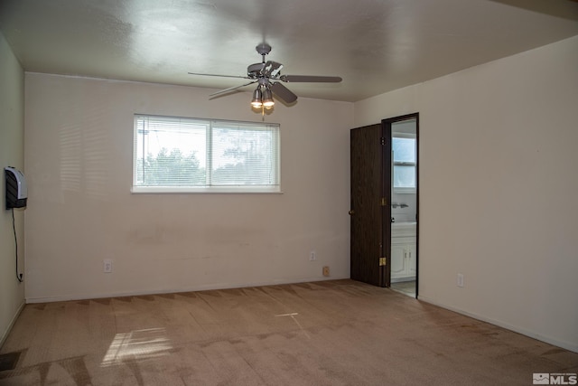 carpeted spare room featuring ceiling fan