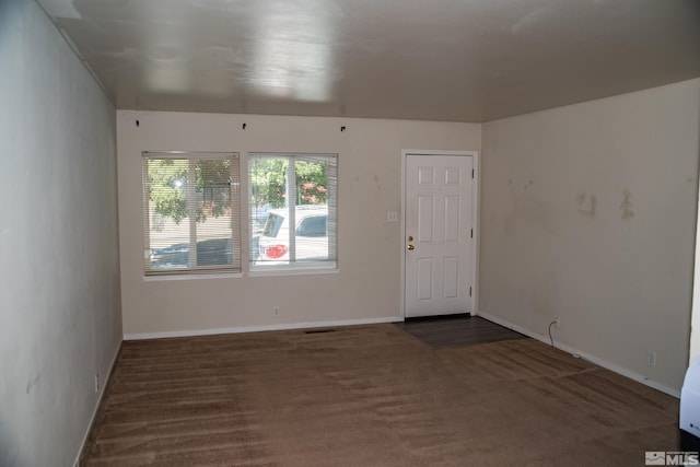 spare room featuring dark colored carpet