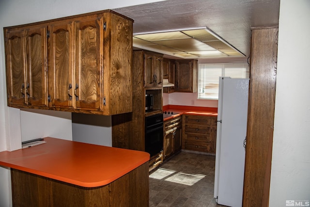 kitchen with black oven and white refrigerator