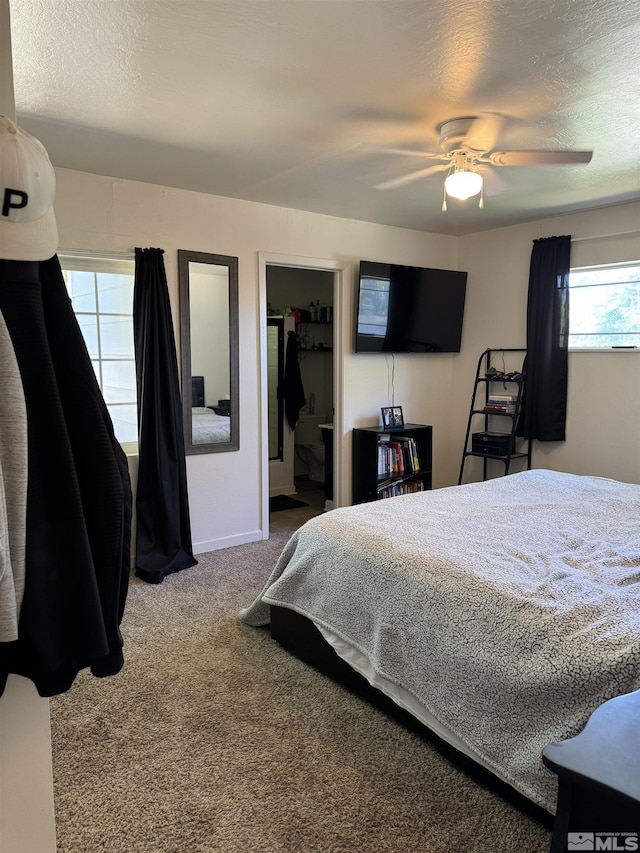 bedroom featuring ceiling fan, carpet floors, a textured ceiling, a walk in closet, and a closet