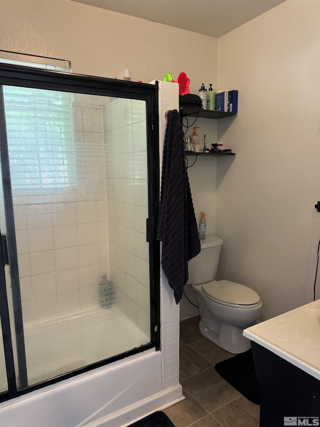 full bathroom featuring tile patterned floors, vanity, enclosed tub / shower combo, and toilet