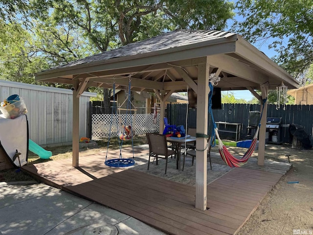 wooden terrace with a gazebo, a grill, and a patio