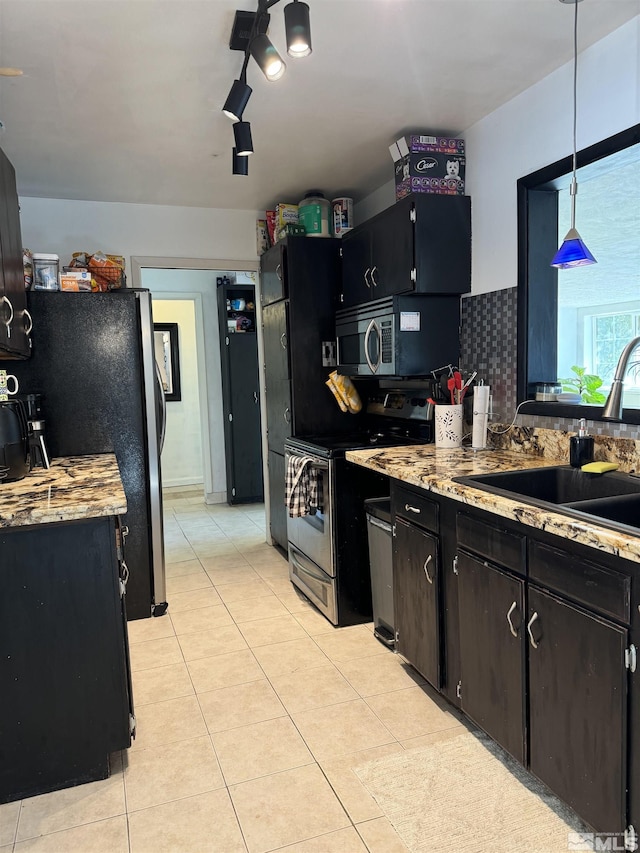 kitchen with sink, hanging light fixtures, tasteful backsplash, light tile patterned floors, and appliances with stainless steel finishes