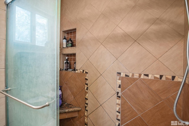 bathroom featuring tile walls and a shower