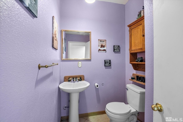 bathroom with sink, toilet, and tile patterned floors