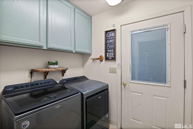 washroom with washer and dryer and cabinets