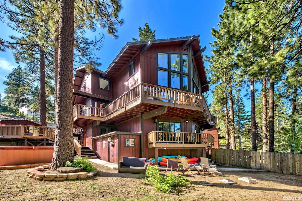 rear view of house with stairs, fence, an outdoor living space, and a patio