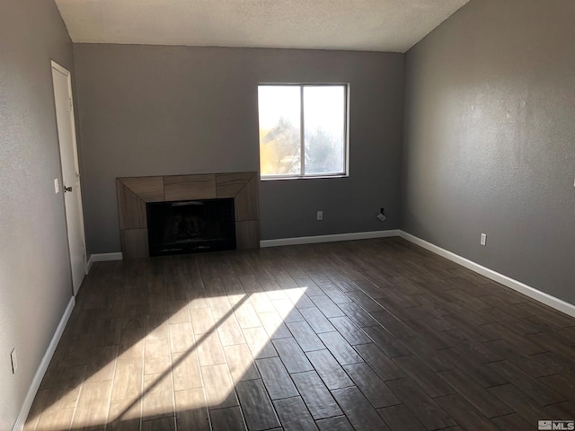 unfurnished living room featuring a tile fireplace and a textured ceiling