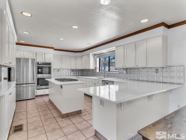 kitchen with white cabinets, a kitchen island, a kitchen bar, and stainless steel appliances