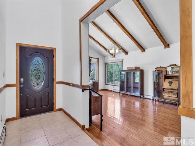 foyer featuring baseboard heating, light hardwood / wood-style floors, lofted ceiling with beams, and an inviting chandelier