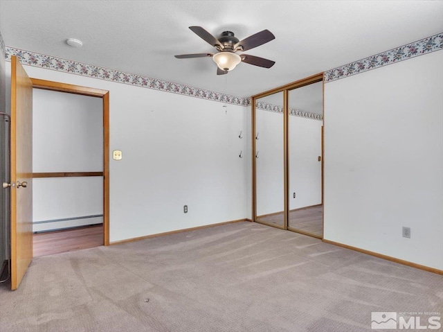 carpeted spare room with baseboard heating and ceiling fan