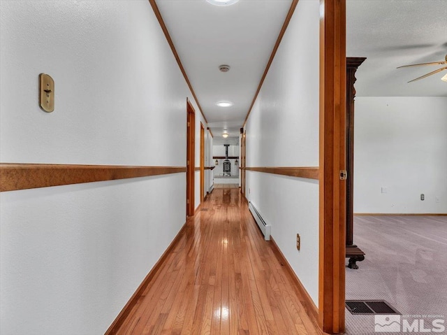 hall with crown molding and a baseboard heating unit