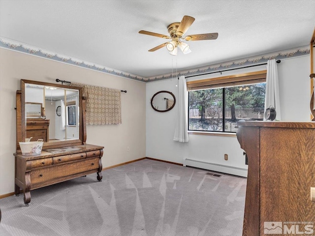 bedroom with a textured ceiling, light colored carpet, ceiling fan, and a baseboard heating unit