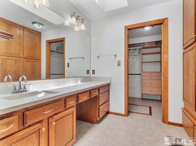 bathroom featuring tile patterned flooring, vanity, and a skylight