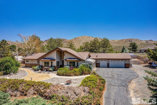 ranch-style home with a mountain view and a garage