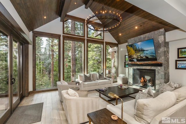 sunroom / solarium with wood ceiling, a stone fireplace, and vaulted ceiling with beams